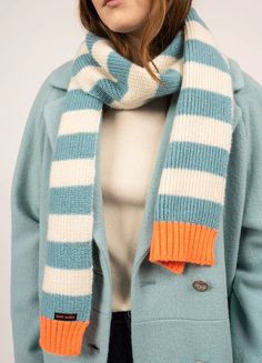 a woman wearing a blue and white striped scarf with an orange stripe on the bottom