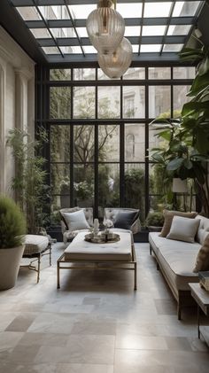 a living room filled with lots of furniture next to a large glass ceiling light hanging from the ceiling