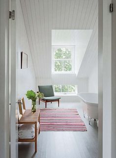 an open door leading to a bathroom with a bathtub and rug on the floor