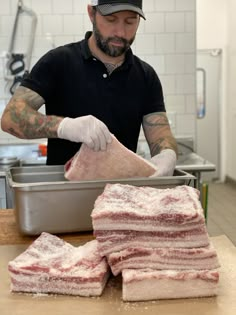 a man in a black shirt and white hat is preparing food on a counter top