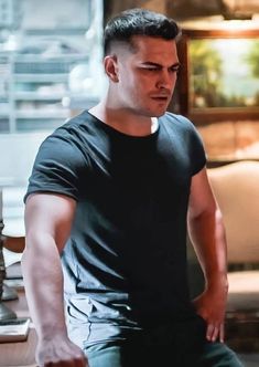 a man in black shirt sitting on top of a chair