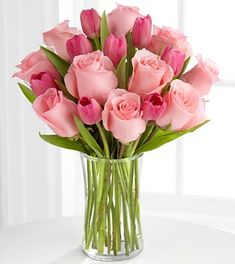 a vase filled with pink roses on top of a table