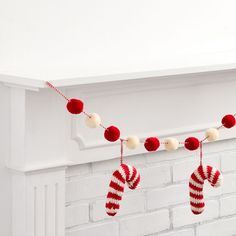 christmas stockings hanging from a mantle with pom - poms