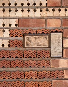 the corner of a brick wall with a small plaque on it's left side