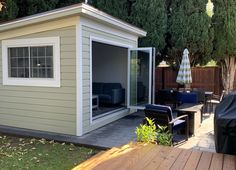 a backyard with a small shed and patio furniture