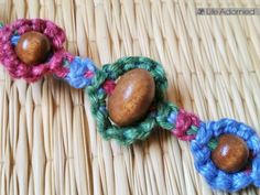 two crocheted beads with wooden buttons on a wicker surface