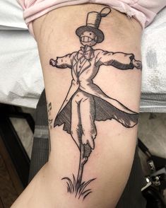 a woman's leg with a tattoo on it that has a drawing of a man in a suit and top hat