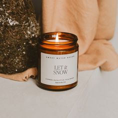 a lit candle sitting on top of a table next to a stuffed animal and pillow