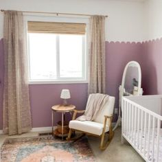 a baby's room with a crib, rocking chair and rug in it