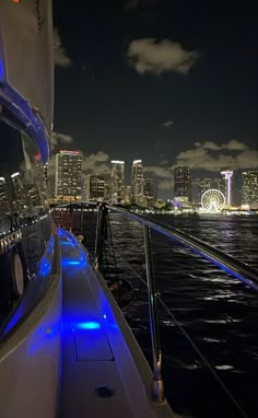 the city lights shine brightly in the distance as seen from a boat on the water