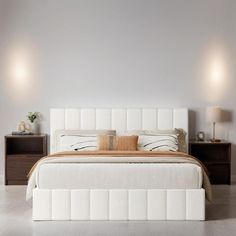 a white bed sitting in a bedroom next to two nightstands