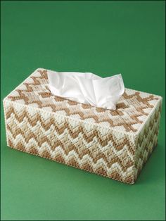 a tissue dispenser sitting on top of a green surface