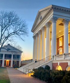 a large white building with columns and steps leading up to it's front entrance