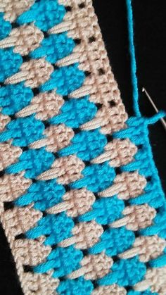 a crocheted blue and white piece of cloth next to a pair of scissors