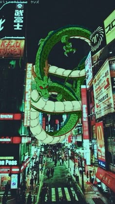 a large green dragon statue on the side of a building in a city at night