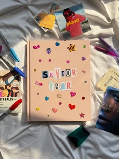 a book with the words senior year written on it surrounded by other school related items