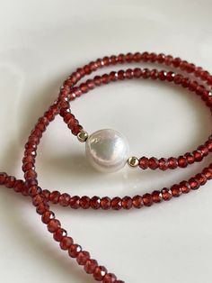 "A lovely 10mm white Edison pearl, slightly-wrinkled and with great luster, is framed by dainty faceted 2mm diamond-cut garnets to make a beaded choker necklace. Sparkles in the sun like crazy! Measures 16\", with a 2\" extender chain to bring it to a total length of 18\". Looks beautiful alone or layered with any other of my garnet necklaces in my shop! Your jewelry will come gift-boxed, and gift-wrapping is available upon request. Thank you for checking out my shop!" Garnet Beads Jewelry, Garnet Bead Necklace, Red Gemstone Necklace, Red Garnet Necklace, Dainty Gemstone Necklace, Red Beaded Necklaces, Beaded Necklace Patterns, Beading Jewelery, Beaded Necklace Diy