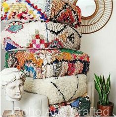 a stack of rugs sitting on top of a white couch next to a mirror