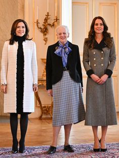 two women standing next to each other on a rug