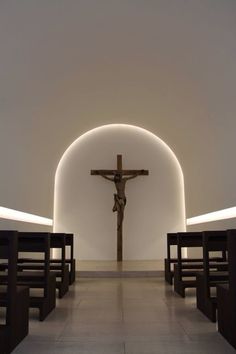 a cross in the middle of a room with benches