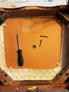 an old wooden box with tools in it and some papers on the floor next to it