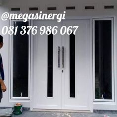 a man standing in front of a white door next to a window with the words megasinerigi on it