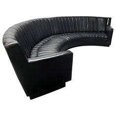 a curved black leather couch on white background