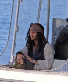 a man with dreadlocks sitting on a boat