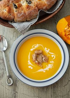 a bowl of soup with bread on the side