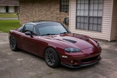 a red sports car parked in front of a house