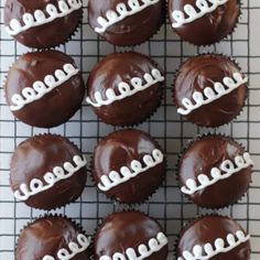 chocolate cupcakes decorated with white frosting on a cooling rack, ready to be eaten