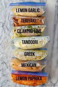 five different types of burritos in plastic bags on a marble countertop with the words lemon garlic teriyaki cilantro time tandoori greek mexican