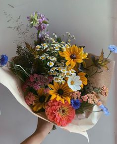 a person holding a bouquet of flowers in their hand