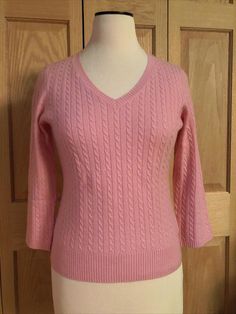 a pink sweater is on a mannequin