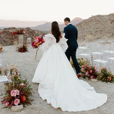 a bride and groom walking down the aisle at their outdoor wedding ceremony in the desert