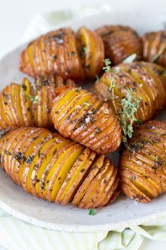 a white plate topped with potatoes covered in herbs