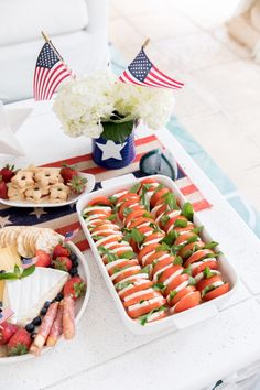 an american flag dessert table with strawberries, cookies and crackers on the side