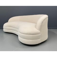 a white couch sitting on top of a gray floor