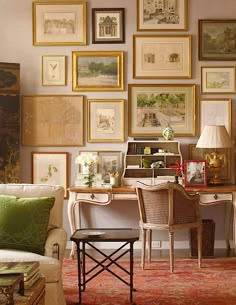 a living room filled with furniture and lots of pictures on the wall above it's desk