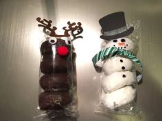 two snowmen made out of doughnuts sitting next to each other in plastic bags