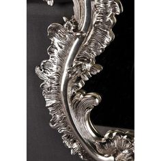 an ornate silver mirror on a black background