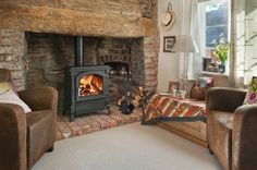 a living room filled with furniture and a fire place in the middle of it's fireplace