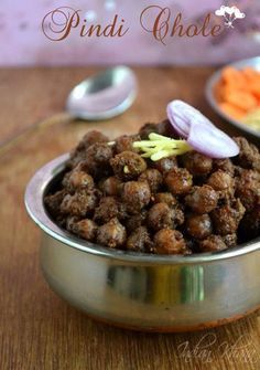 a metal bowl filled with food on top of a wooden table