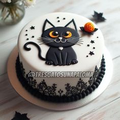 a white cake with black and orange decorations on it's side, decorated with a cat