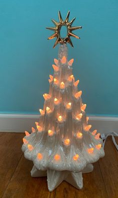 a christmas tree made out of plastic bottles with candles in it and a star on top