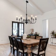 a dining room table with chairs and a chandelier