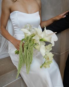 a woman in a wedding dress holding a bouquet