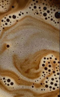 some brown and white liquid in a glass bowl with black dots on the bottom,