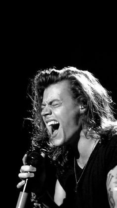 a black and white photo of a woman singing into a microphone with her mouth open