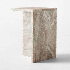 a white marble table with a square shaped top on the bottom, and an angled edge